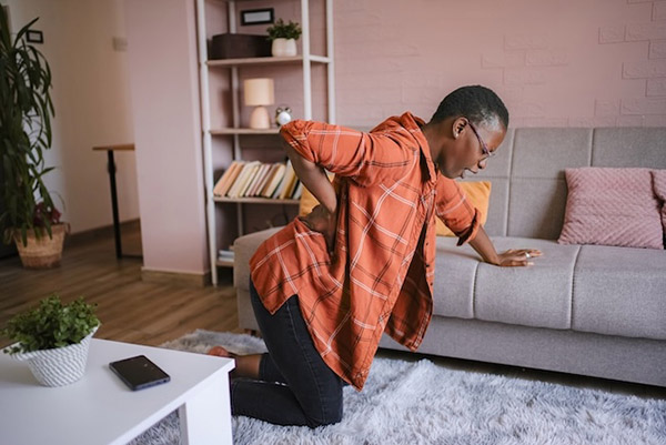 Person experiencing delayed back pain days after a car accident at home
