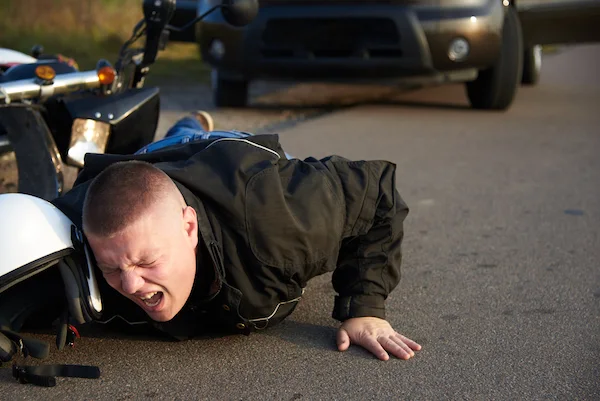 A motorcyclist lies on the asphalt after a motorcycle accident in Georgia.